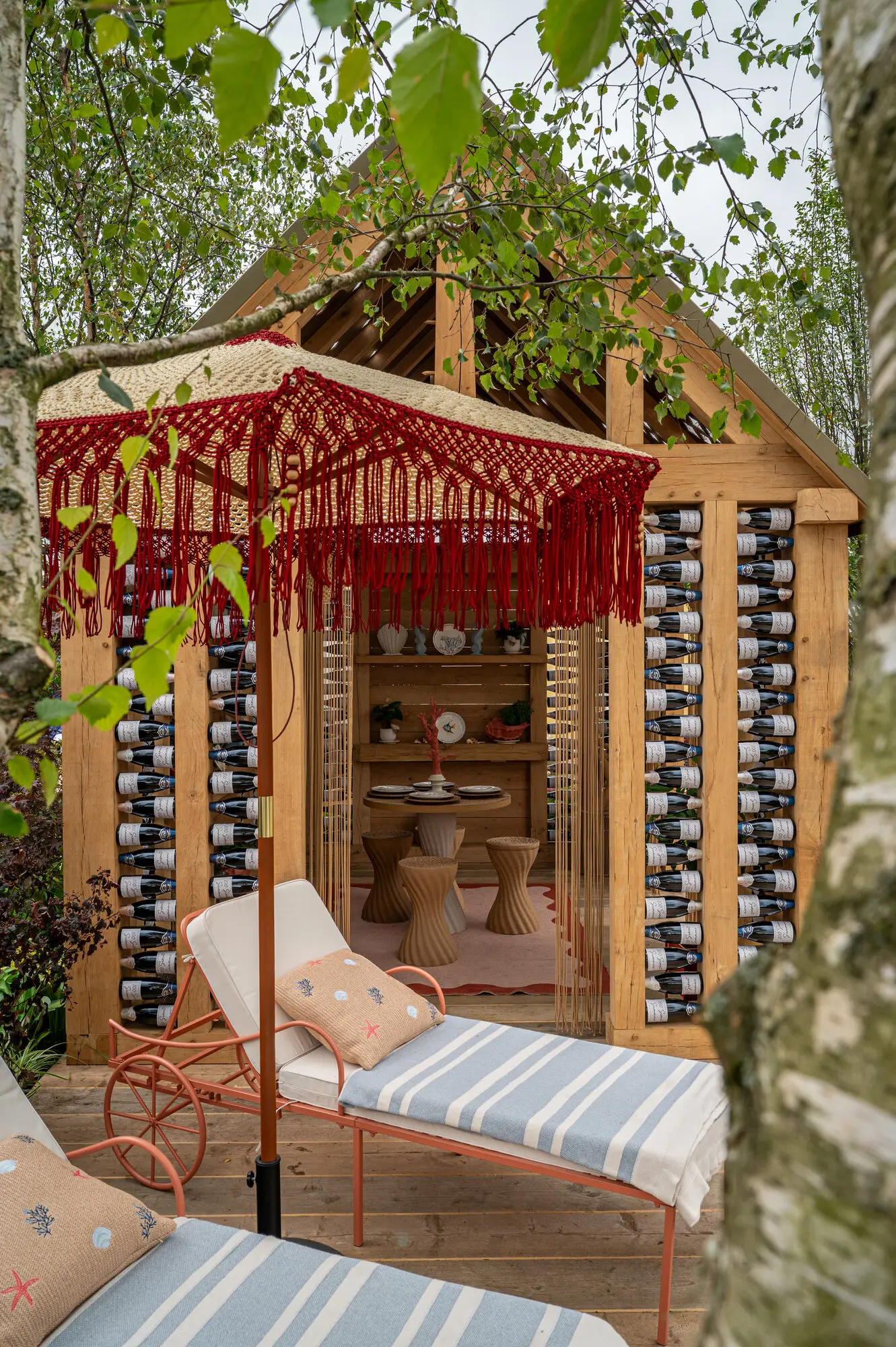Relaxing seating area with handmade macramé parasol, birch trees and planting in the 100 Sweet Summers garden