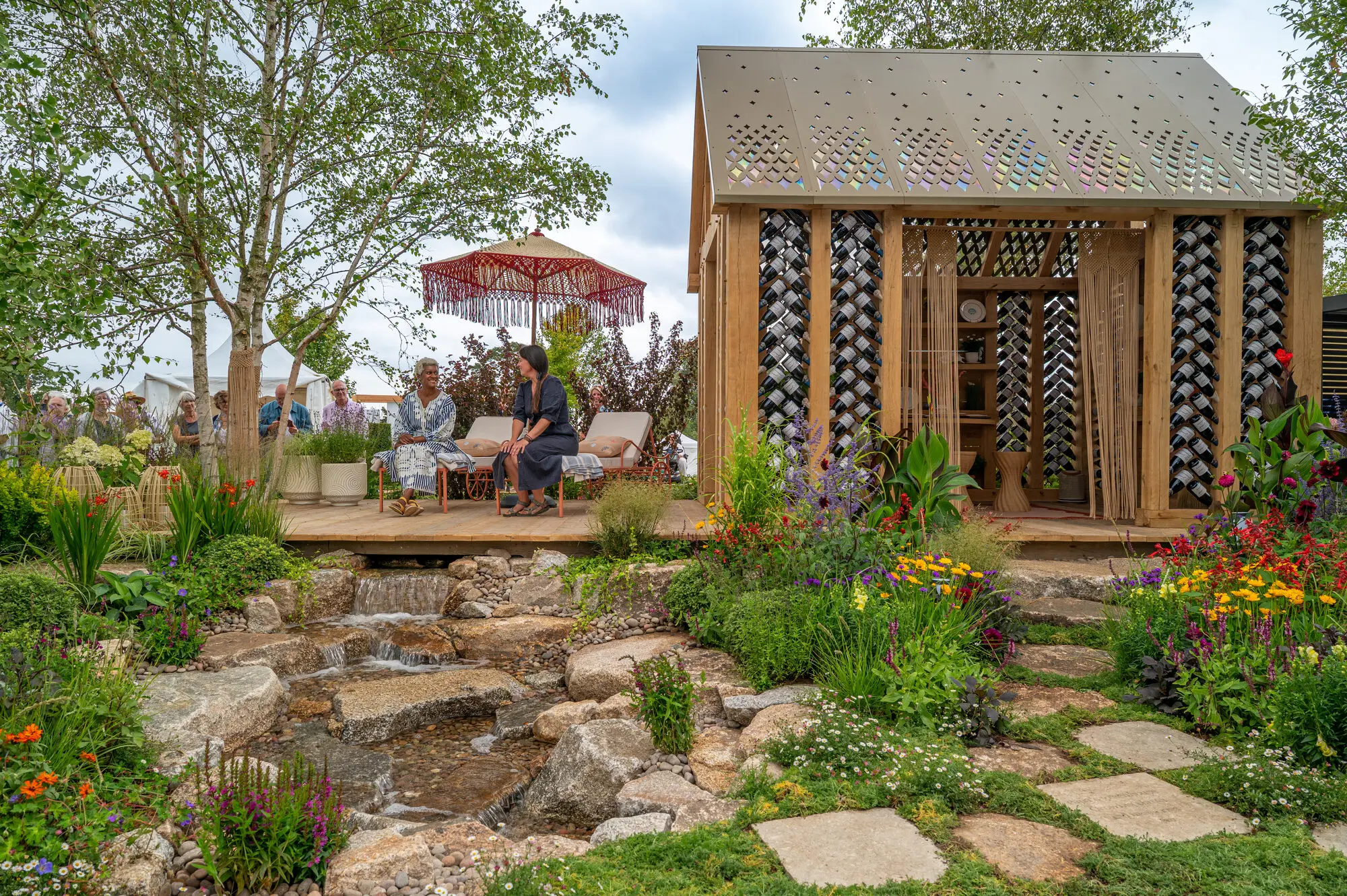 Visitors experiencing the planting, water and seating areas of the 100 Sweet Summers show garden