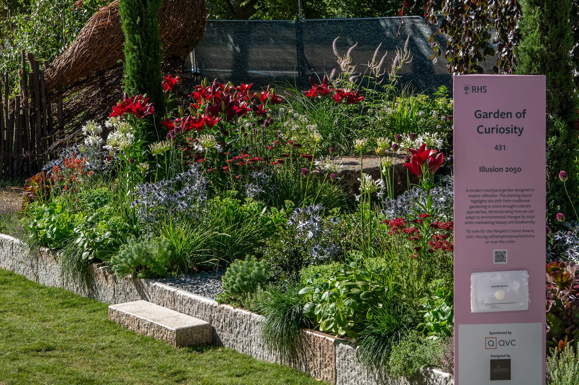 The courtyard planting with the granite seat and the RHS garden sign, which names the Garden of Curiosity category