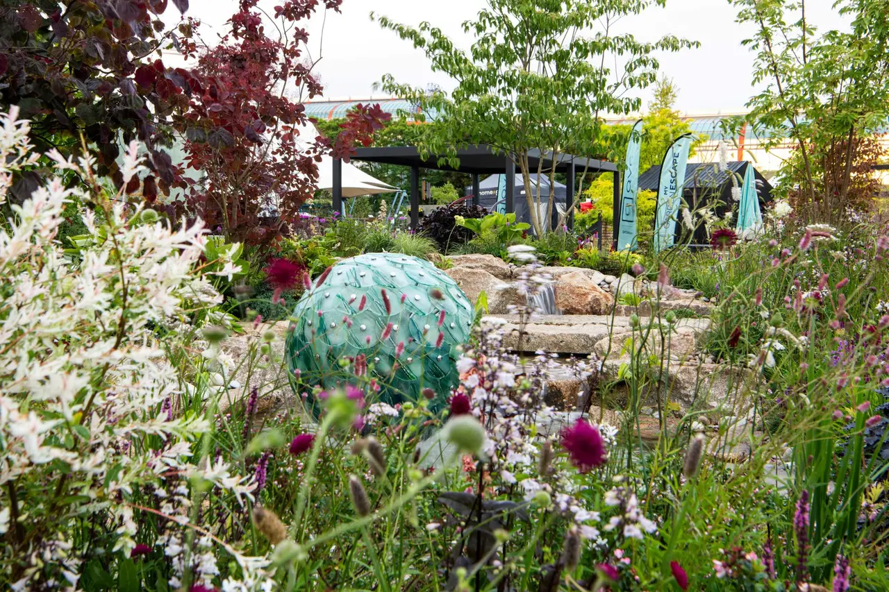 QVC's Reflective Retreat show garden at BBC Gardeners' World Live 2025, with the glass water feature, the waterfall and layered planting