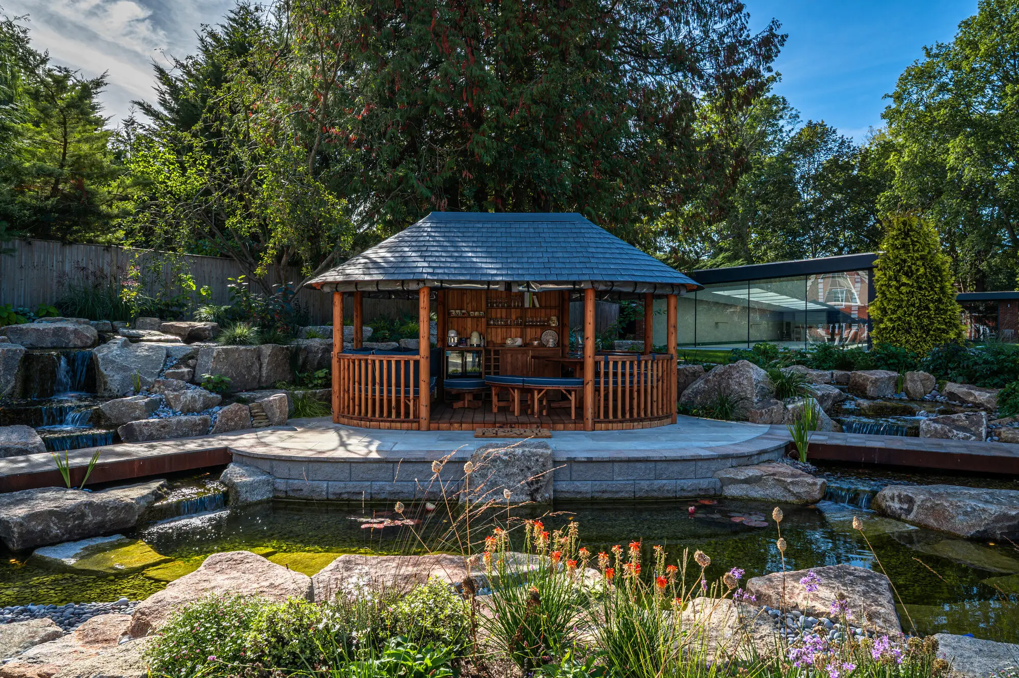 The Breeze House on its island across the pond, granite waterfalls on both sides and red hot pokers flowering at the water's edge